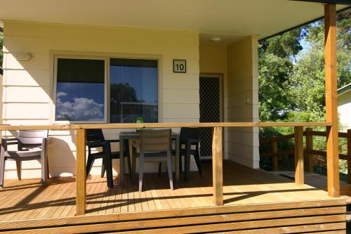 a deck with a table and chairs on a house at Millicent Hillview Caravan Park in Millicent