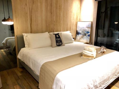 a bedroom with a bed with a pillow and towels at Something Easy Inn in Jiufen
