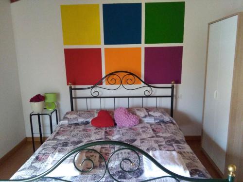 um quarto com uma cama com uma parede colorida em Casali Scjs em Venzone