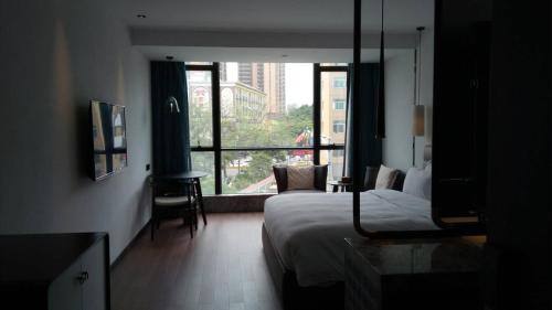 a hotel room with a bed and a window at 柏高酒店-深圳公明广场地铁站店 in Bao'an