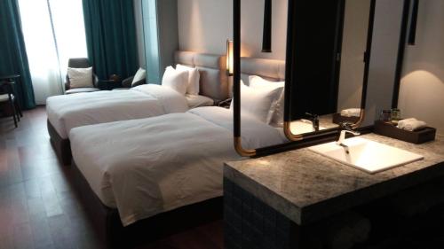 a hotel room with two beds and a mirror at 柏高酒店-深圳公明广场地铁站店 in Bao'an
