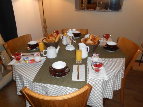 a table with food and baskets of bread on it at Hôtel-Restaurant "Chez Carrière" in Aigues-Mortes