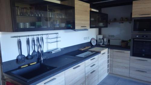 a kitchen with a sink and a counter with utensils at RESIDENCE U RE D' ALZETTU in Porto-Vecchio