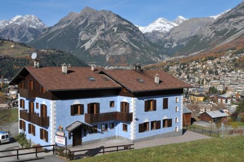 una grande casa con montagne sullo sfondo di Hotel Eira a Bormio