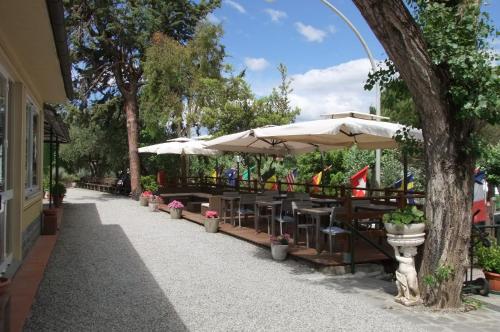 un patio con mesas y sombrillas en una acera en Camping Fossa Lupara en Sestri Levante