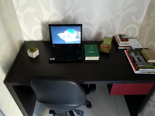 a laptop computer sitting on top of a black desk at Hotel Dina in Međugorje