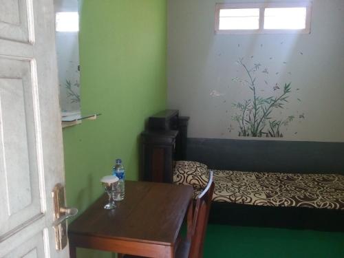 a small room with a table and a bed at Pendopo Kayuwanan Syariah Near Terminal Giwangan in Yogyakarta