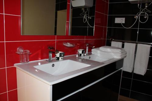 a bathroom with a white sink and a red wall at Cascata do Varosa - Turismo Rural in Vila Pouca