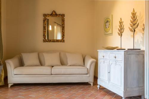 a living room with a couch and a mirror at Relais La Costa Historical Residence in Monteriggioni