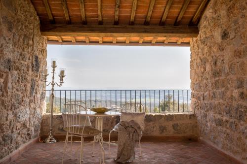 a balcony with a table and chairs and a view of the ocean at Relais La Costa Historical Residence in Monteriggioni