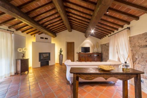 a living room with a white couch and a table at Relais La Costa Historical Residence in Monteriggioni