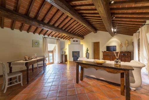 a large living room with wooden ceilings and a table at Relais La Costa Historical Residence in Monteriggioni