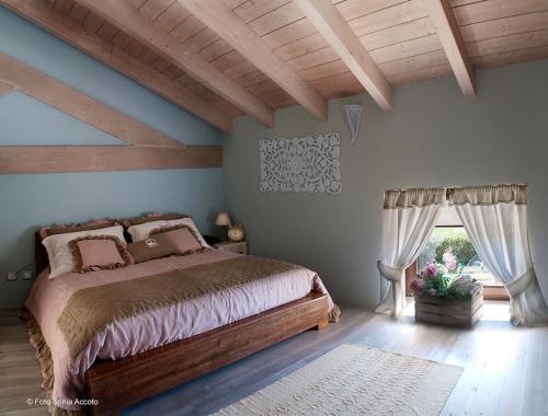 a bedroom with a bed and a wooden ceiling at Palascìa Wellness Relais in Otranto