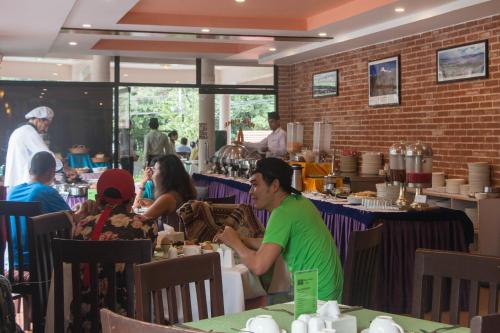 a group of people sitting at tables in a restaurant at Mount Kailash Resort in Pokhara