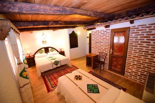 a bedroom with two beds and a brick wall at Hotel Tradita in Shkodër
