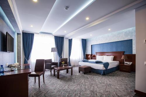 a hotel room with a large bed and a large window at Central Hotel in Yerevan