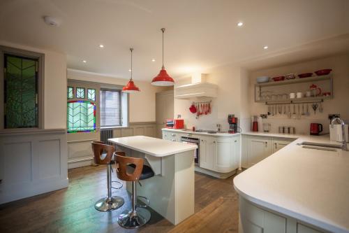 a kitchen with white cabinets and a white counter top at Ludlow - Linnet House - Well Presented Townhouse With Parking - Perfect Location For Exploring On Foot, Sleeps Up To 8 Guests - Hosted by RENTMYHOUSE in Ludlow