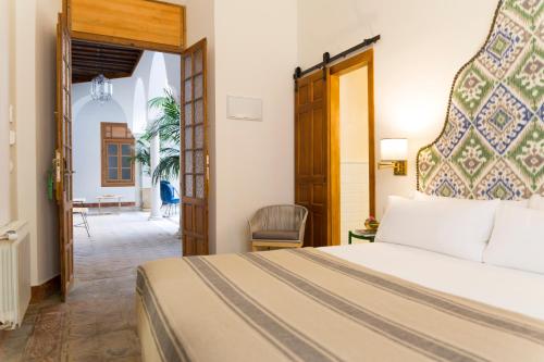 a hotel room with a bed and a chair at nüa santiago15 in Seville