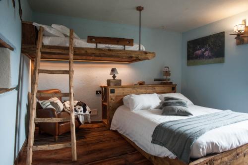 a bedroom with two bunk beds and a chair at Lous Escartoun in Pragelato