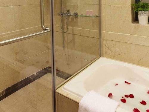 a bathroom with a shower and a bath tub with blood at 广州丹顿行政公寓珠江新城店-广交会期间免费穿梭巴士 in Guangzhou