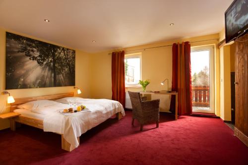 a bedroom with a bed and a large window at Landhotel Grashof in Mittelkalbach