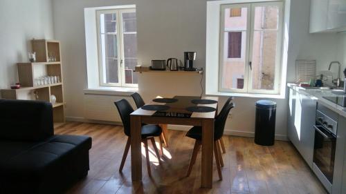 een keuken met een tafel en stoelen in een kamer bij Gîte les 3 tours 1e étage in Carcassonne