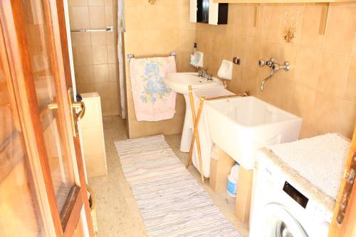 a bathroom with a sink and a toilet and a tub at Solemar in San Vito lo Capo