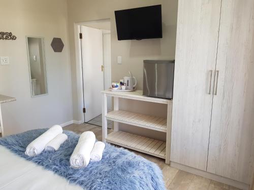 a room with a bed with towels on a blue rug at Outeniqua en Route in George