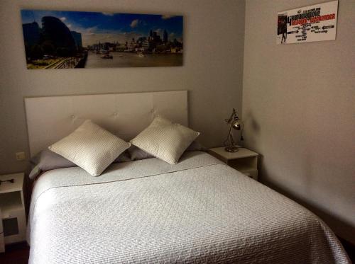 a bedroom with a white bed with two pillows at Macky's Pad in Pontevedra
