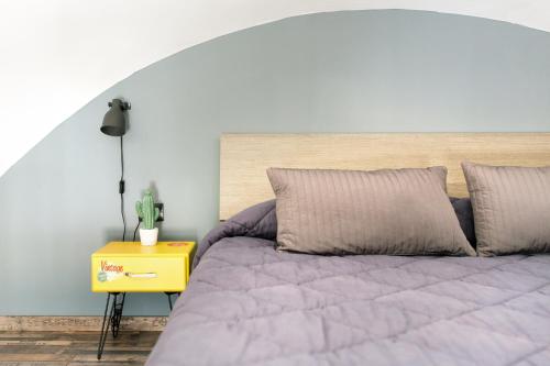 um quarto com uma cama e uma mesa de cabeceira amarela em Casabera em Trani