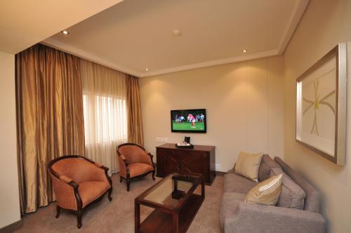 a living room with a couch and two chairs at Apollo Hotel in Johannesburg