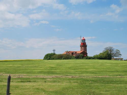 a lighthouse sitting on top of a lush green field at Wohnung in Neubukow nahe Ostseestrand in Neubukow