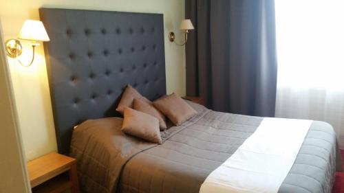 a bedroom with a bed with two pillows on it at Hostellerie Reeb in Marlenheim