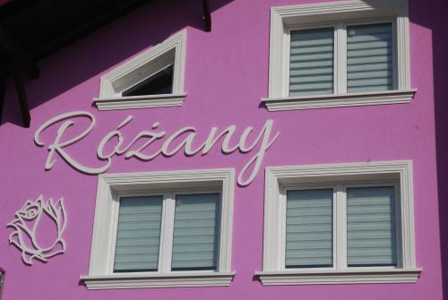 a pink building with the wordakura painted on it at Noclegi"DOM RÓŻANY" Myszyniec in Myszyniec
