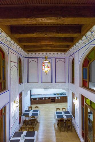 a room with tables and chairs and a chandelier at Hotel Volida Boutique in Bukhara