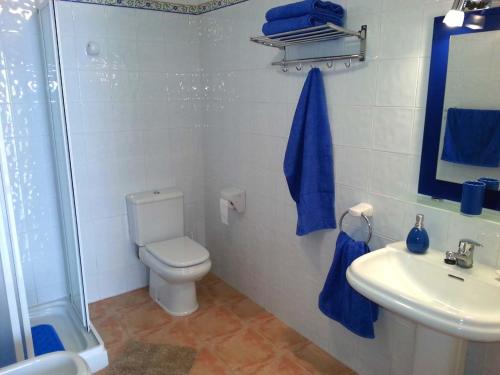 ein Badezimmer mit einem WC und einem Waschbecken mit blauen Handtüchern in der Unterkunft Apartment Vistamar 2 in Cumbre del Sol