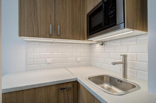 eine Küche mit einer Spüle und einer Mikrowelle in der Unterkunft DR Apartments - Five in Sopot