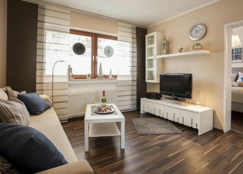 Una sala de estar con un sofá, un televisor y una mesa. en Rosalie - Lake - Hiking&Swimming - Cozy&Nature, en Winterberg