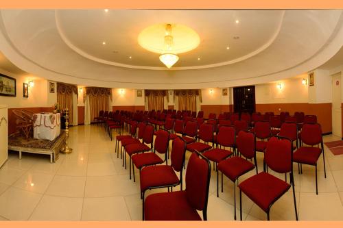 a large room with red chairs and a ceiling at Hotel Grand Palace in Kodaikānāl