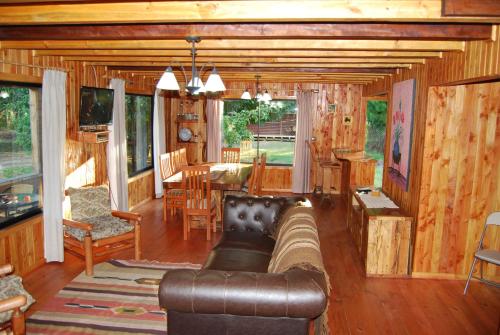 a living room with a leather couch and a dining room at Cabanas de Monasterio in Puerto Clocker