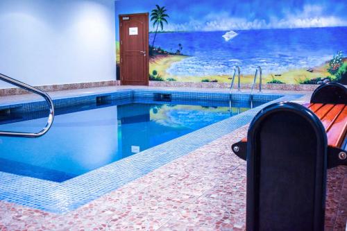 a swimming pool with a mural of a beach at Sapphire Plaza Hotel in Doha