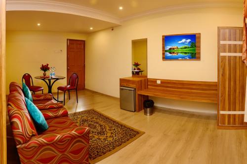 a living room with a couch and a desk at Hotel Grand Palace in Kodaikānāl