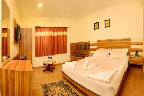 a bedroom with a large bed in a room at Hotel Grand Palace in Kodaikānāl