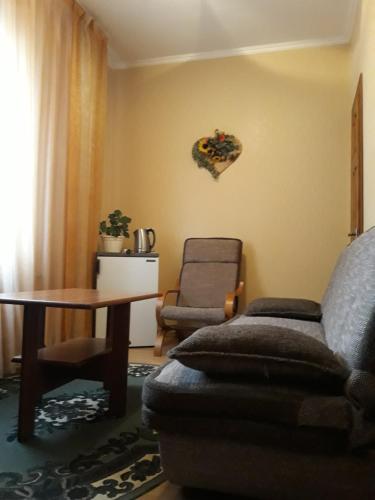 a living room with a couch and a table and a chair at Сонячна in Truskavets