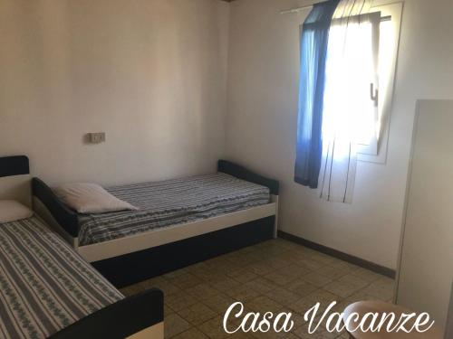 a small bedroom with two beds and a window at Bungalows Alloggi Angiolin Ketty in Cavallino-Treporti
