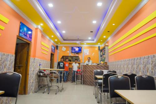a restaurant with a bar with people standing at the counter at Galaxy Guest House in Bhairāhawā