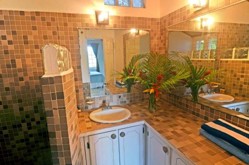 a bathroom with two sinks and a large mirror at Moon San Villa at the Blue Lagoon in Port Antonio