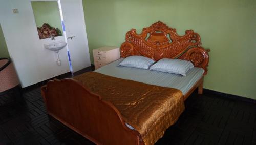 1 dormitorio con cama con cabecero de madera y lavamanos en SONA VILLA, THE LAKE CHALET, en Kudāl