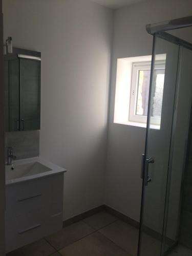 La salle de bains est pourvue d'un lavabo, d'une douche et d'une fenêtre. dans l'établissement le pavillon pierre naturelle, à Jaujac