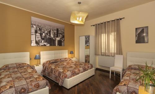 ピサにあるHotel Il Giardinoのベッド2台と鏡が備わるホテルルームです。